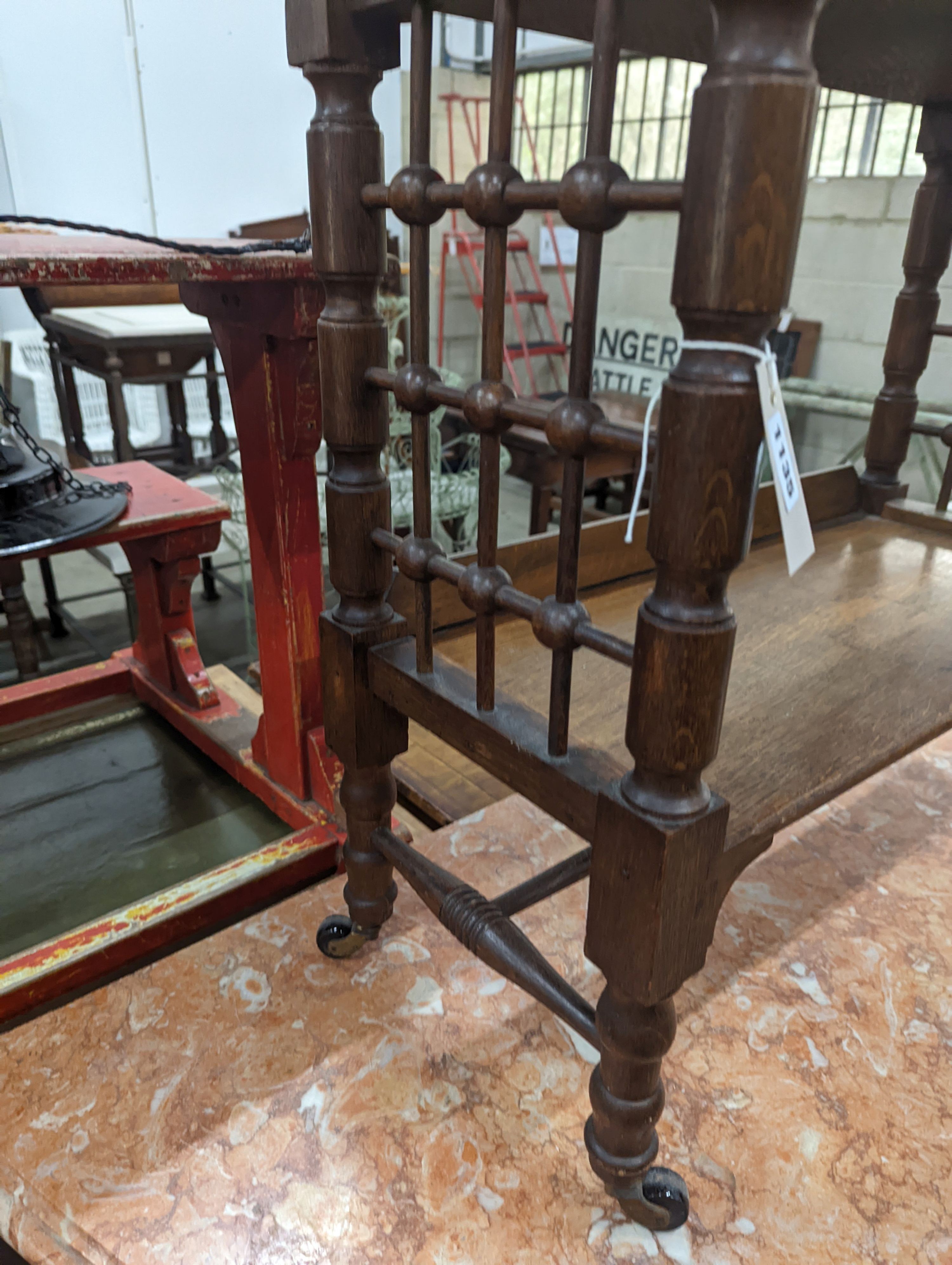 A late 19th century Continental oak three tier Liberty style table with slant top, width 70cm, depth 29cm, height 78cm